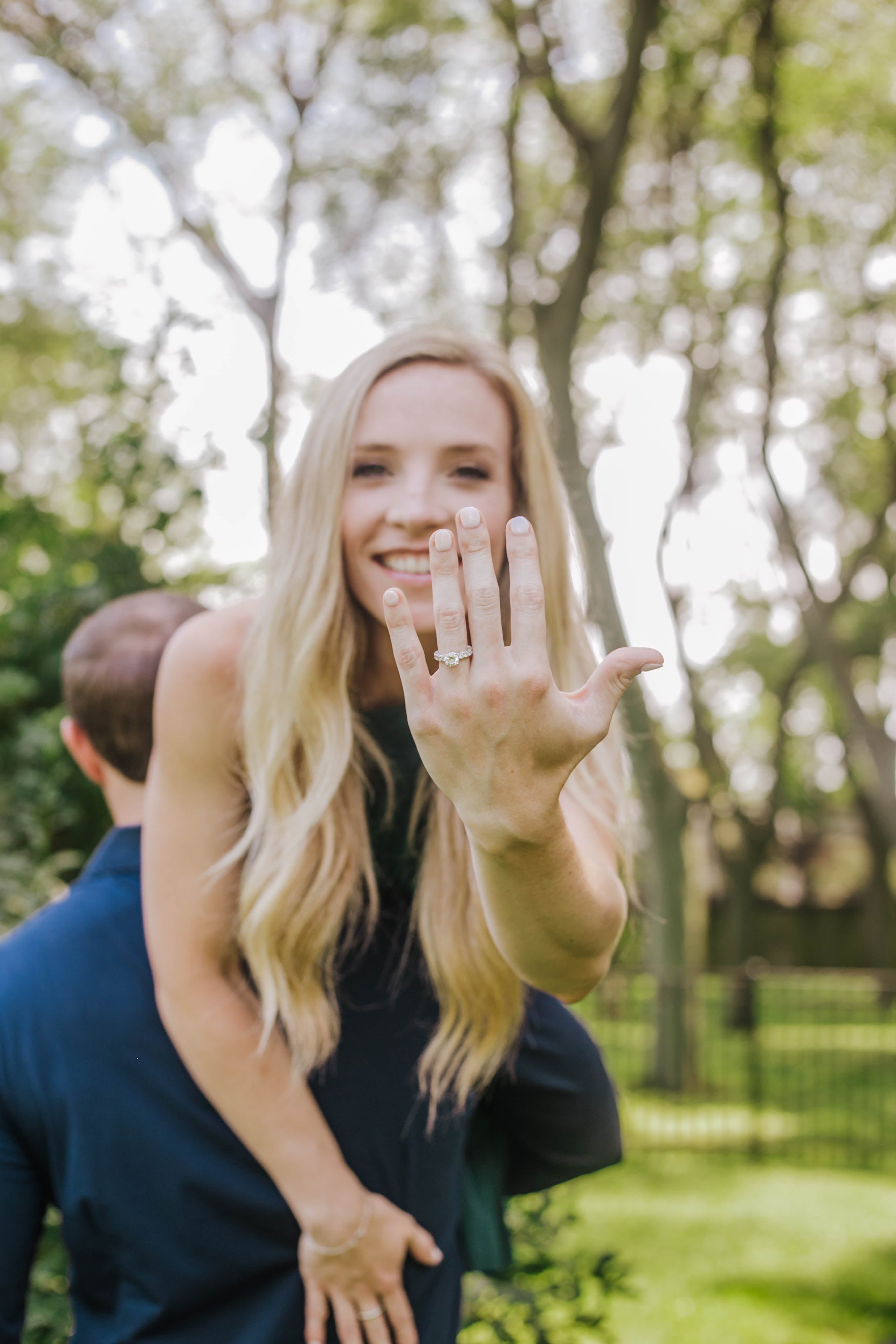 Megan smiling on Tyler's back, showing her engagement ring on her left hand