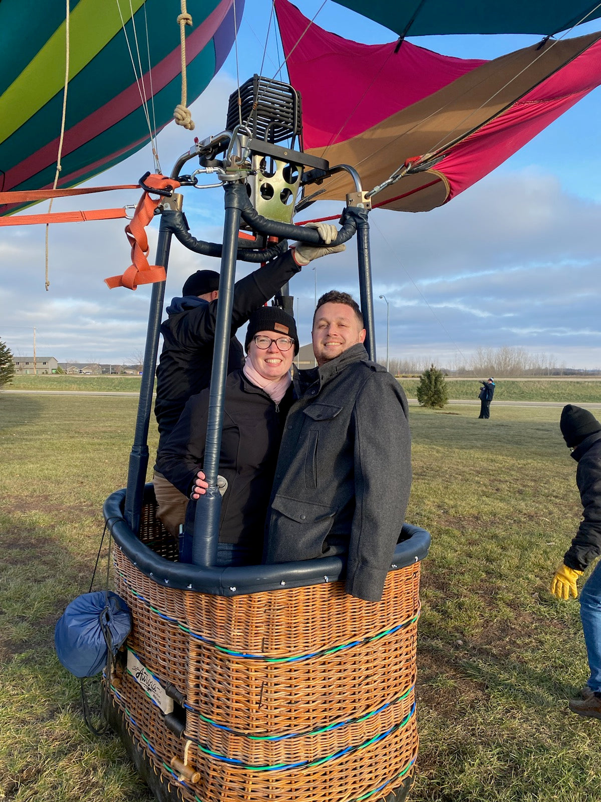 Ruth and Caleb smiling inside a hot-air balloon wicker basket before takeoff