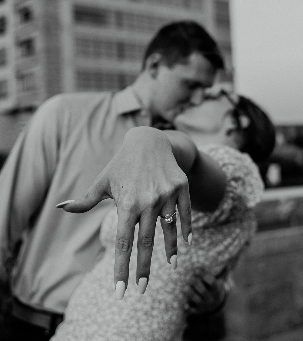 Hailey and Jack kissing as Hailey extends her left hand to show an engagement ring