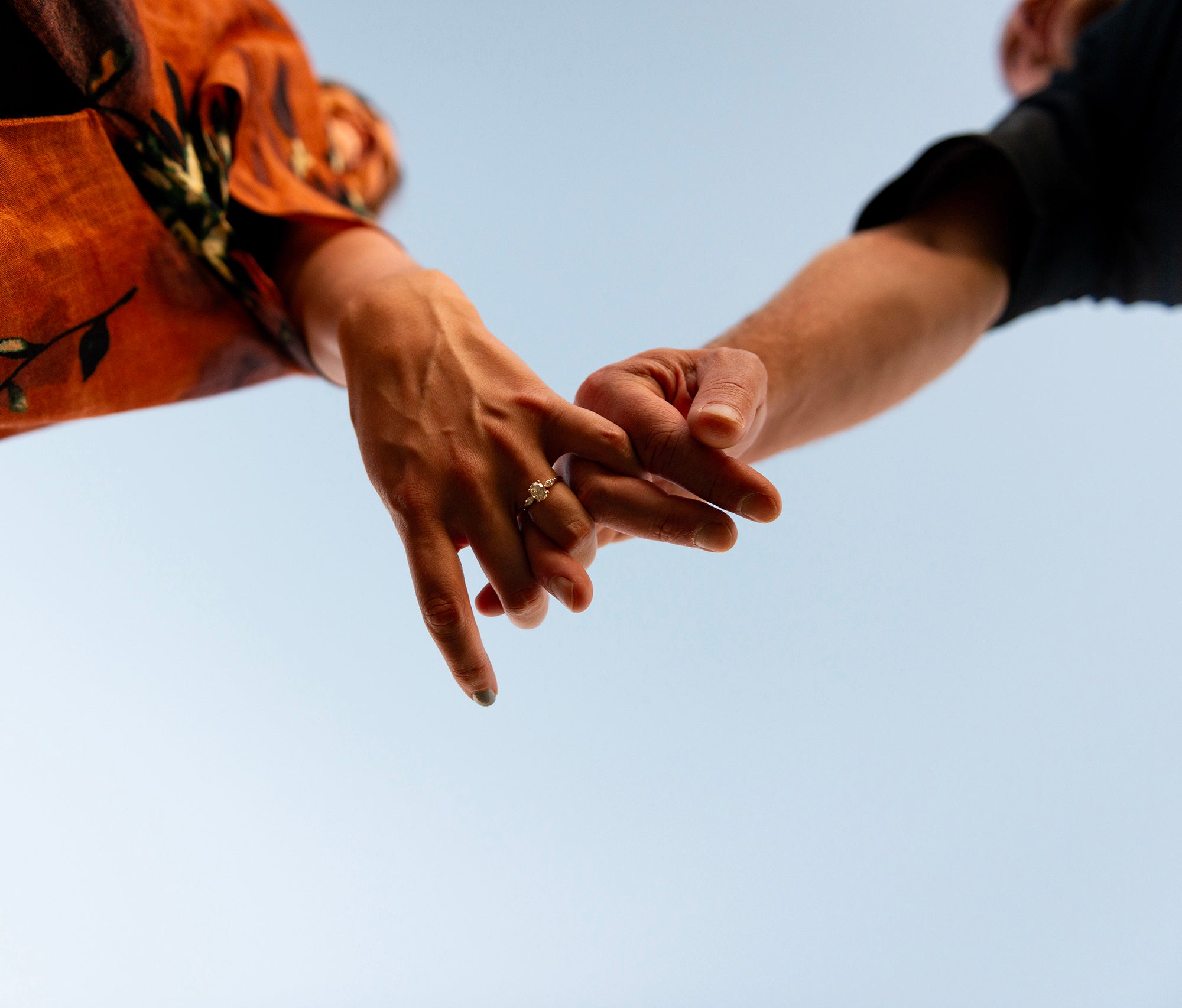 Amy and Matt holding hands, woman's hand shows engagement ring