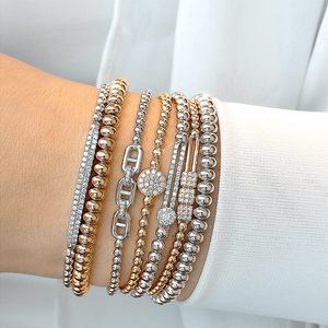 Wrist shot of Tresore 0.24ctw 18K yellow gold stretch bracelet stacked with other gold bracelets and diamond accents