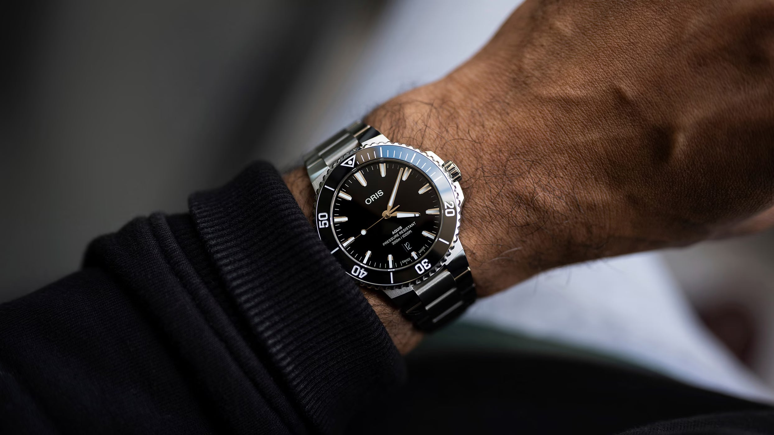 Close-up of a wrist wearing a black watch with a blurred background
