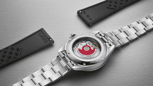Silver watch with open case on a metallic surface