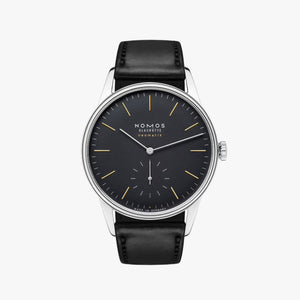 Nomos watch with black dial and leather strap on a white background
