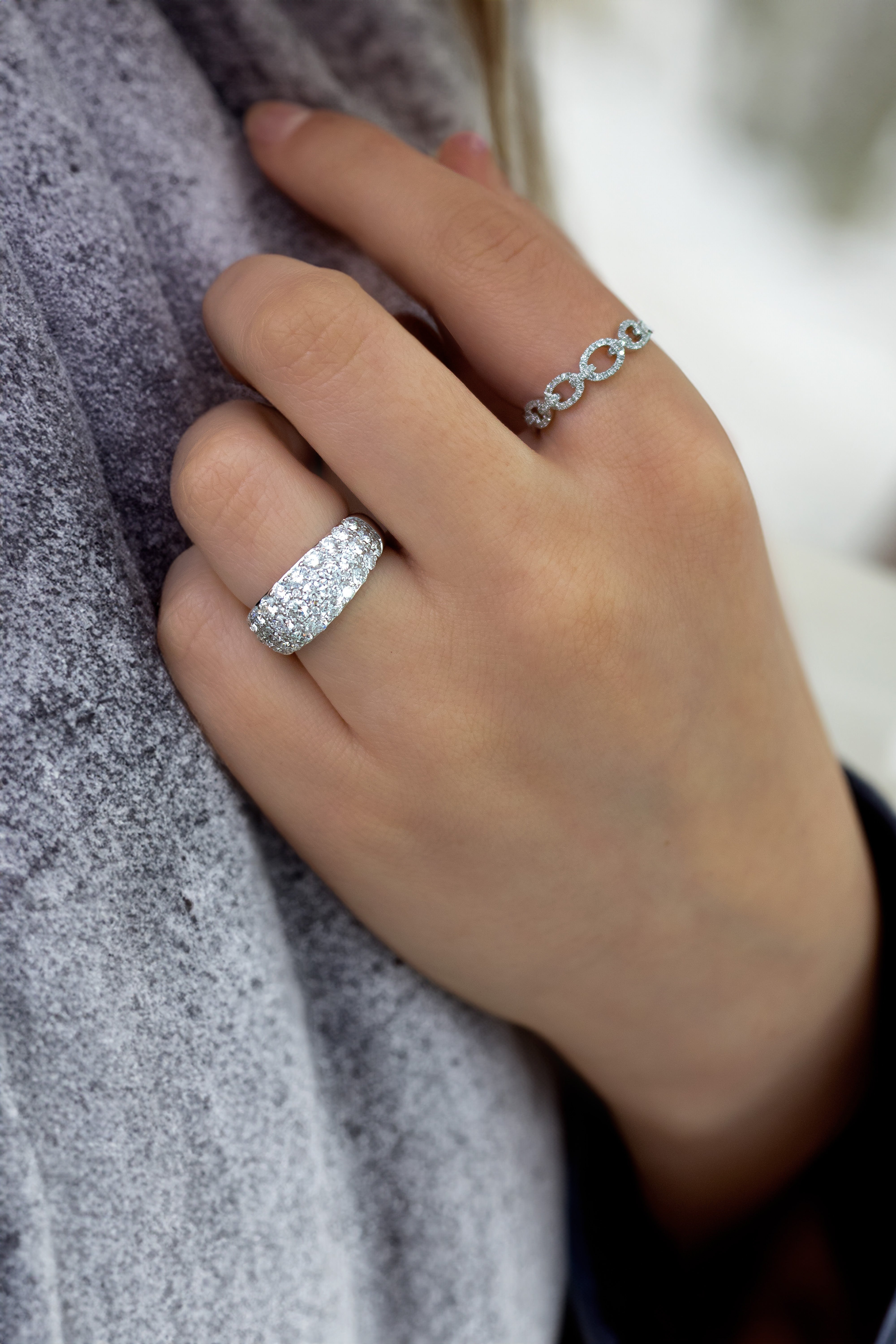 Close-up of hand wearing 0.23ctw Diamond Link Ring in 14K white gold, showing linked circle diamond detail on gray background