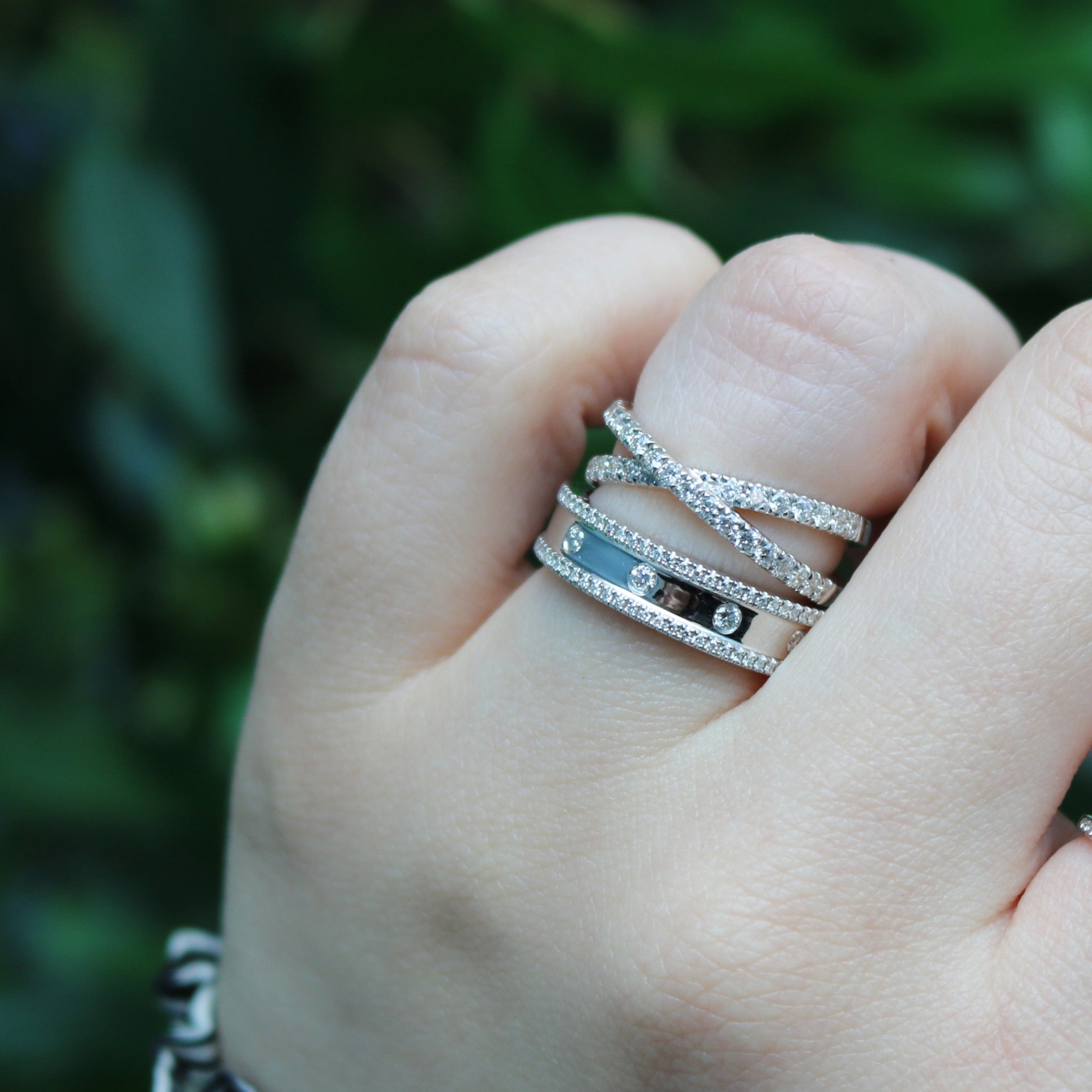 Close-up of 0.23ctw diamond fashion ring in white gold on a hand, crisscross pave bands and three small diamonds