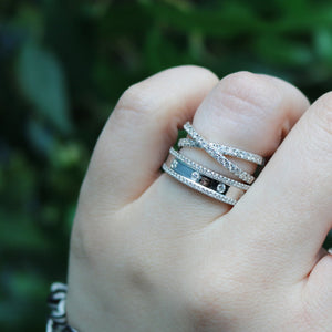 Close-up of 0.23ctw diamond fashion ring in white gold on a hand, crisscross pave bands and three small diamonds