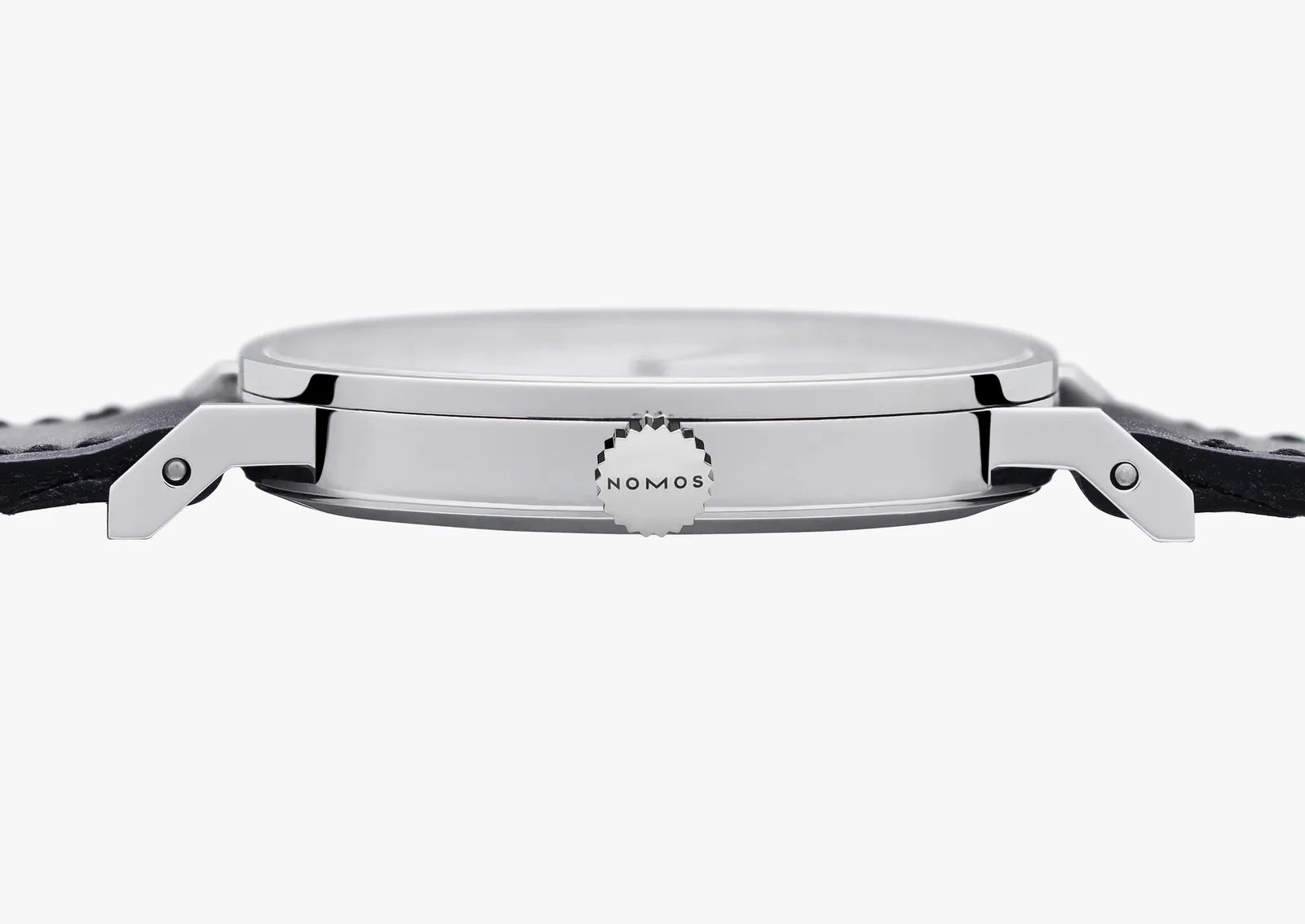 Close-up side view of a silver-toned wristwatch with a black strap, showing the side lugs and a small circular dial detail marked NOMOS on a light gray background.