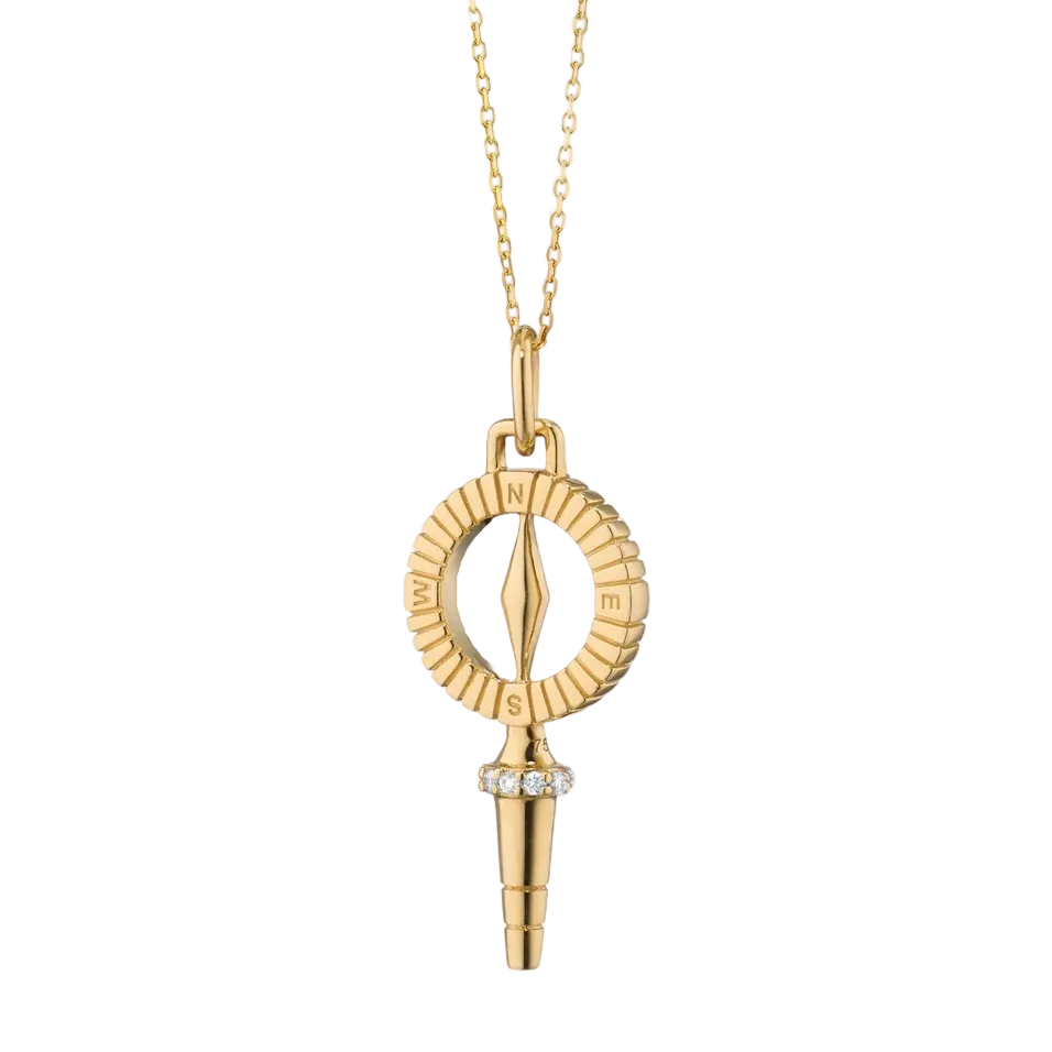 gold compass key necklace on a white background