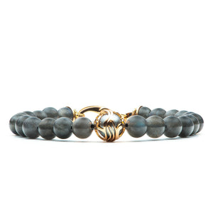 Straight-on view of William Henry Moonlight bracelet with gray beads and gold filigree clasp featuring central pearl on white