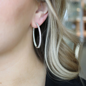 Close-up side view of 3.03ctw diamond hoop earring showcasing pavé diamonds in 14K white gold worn on model's ear