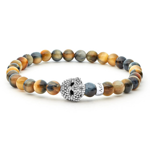 Close-up of tigereye gemstone bracelet showcasing sterling silver Caviar skull bead and 6mm beads on white background