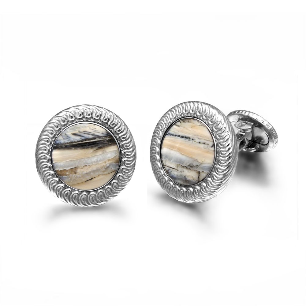 Angled view of William Henry woolly mammoth cufflinks with round fossil-tooth inlays and silver rope-edge bezels on white