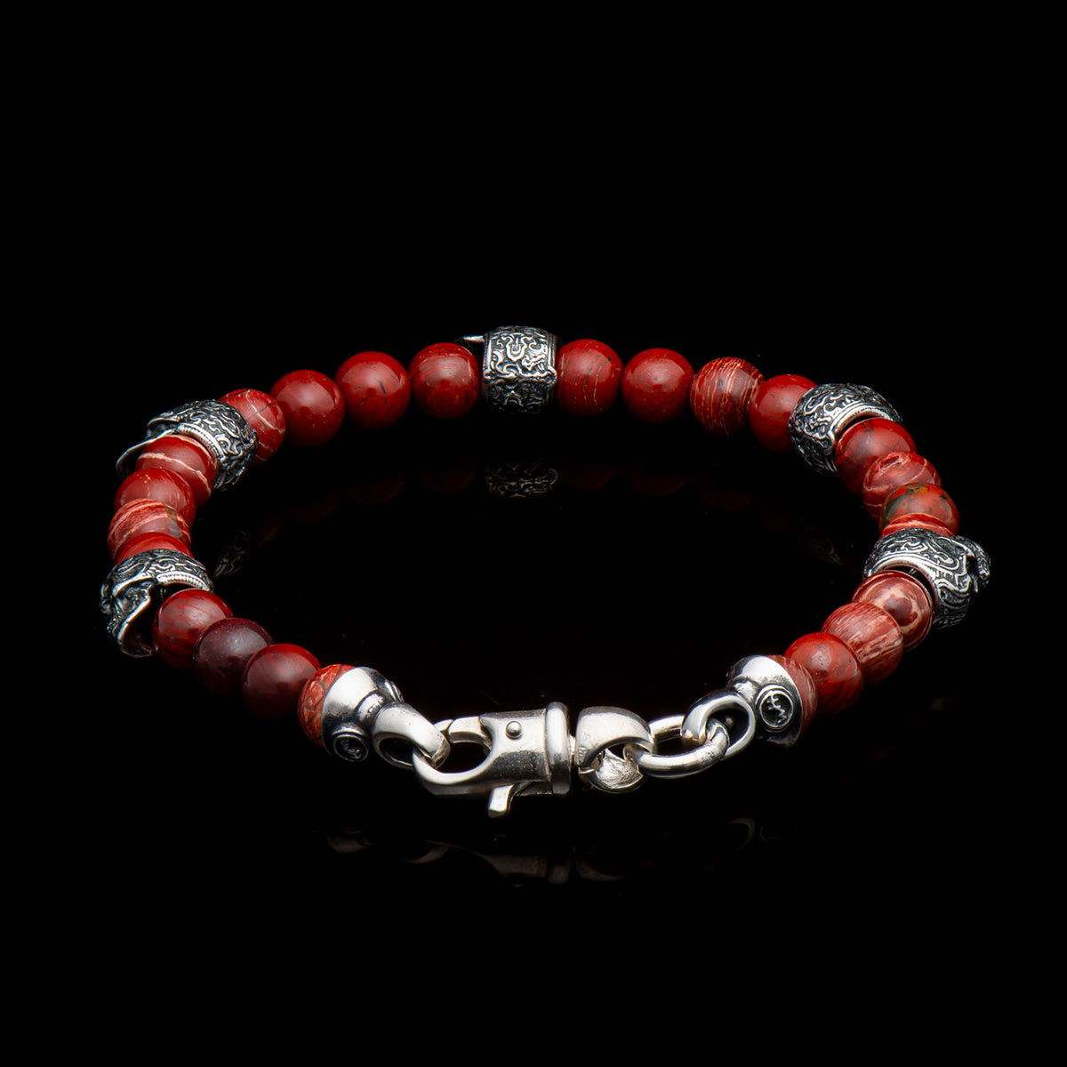 Red jasper bead bracelet with ornate silver spacer beads and lobster-style clasp