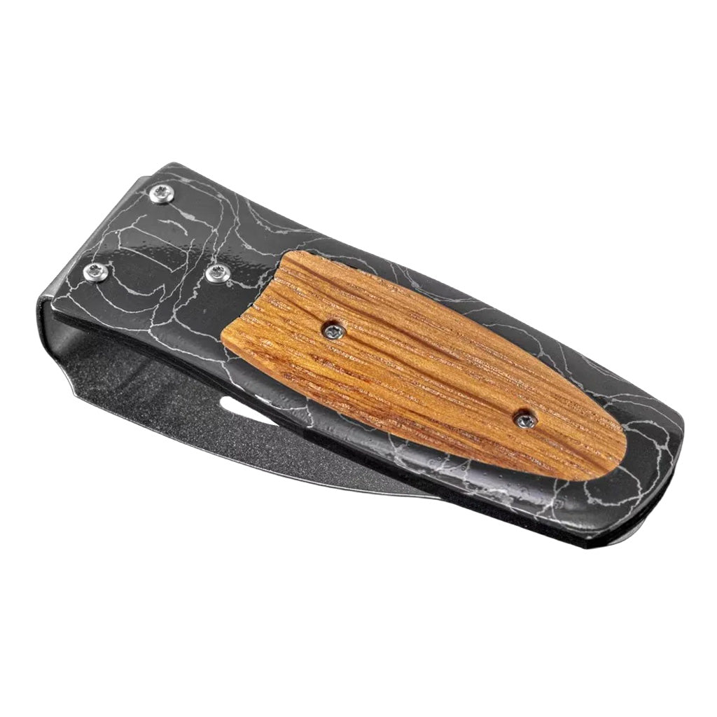 Three-quarter view of William Henry Pappy money clip showing black T‑Rex Damascus frame with white marbling and wooden inlay on white background