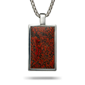 Rectangular silver pendant with red-and-black patterned dinosaur-bone inlay on a silver chain