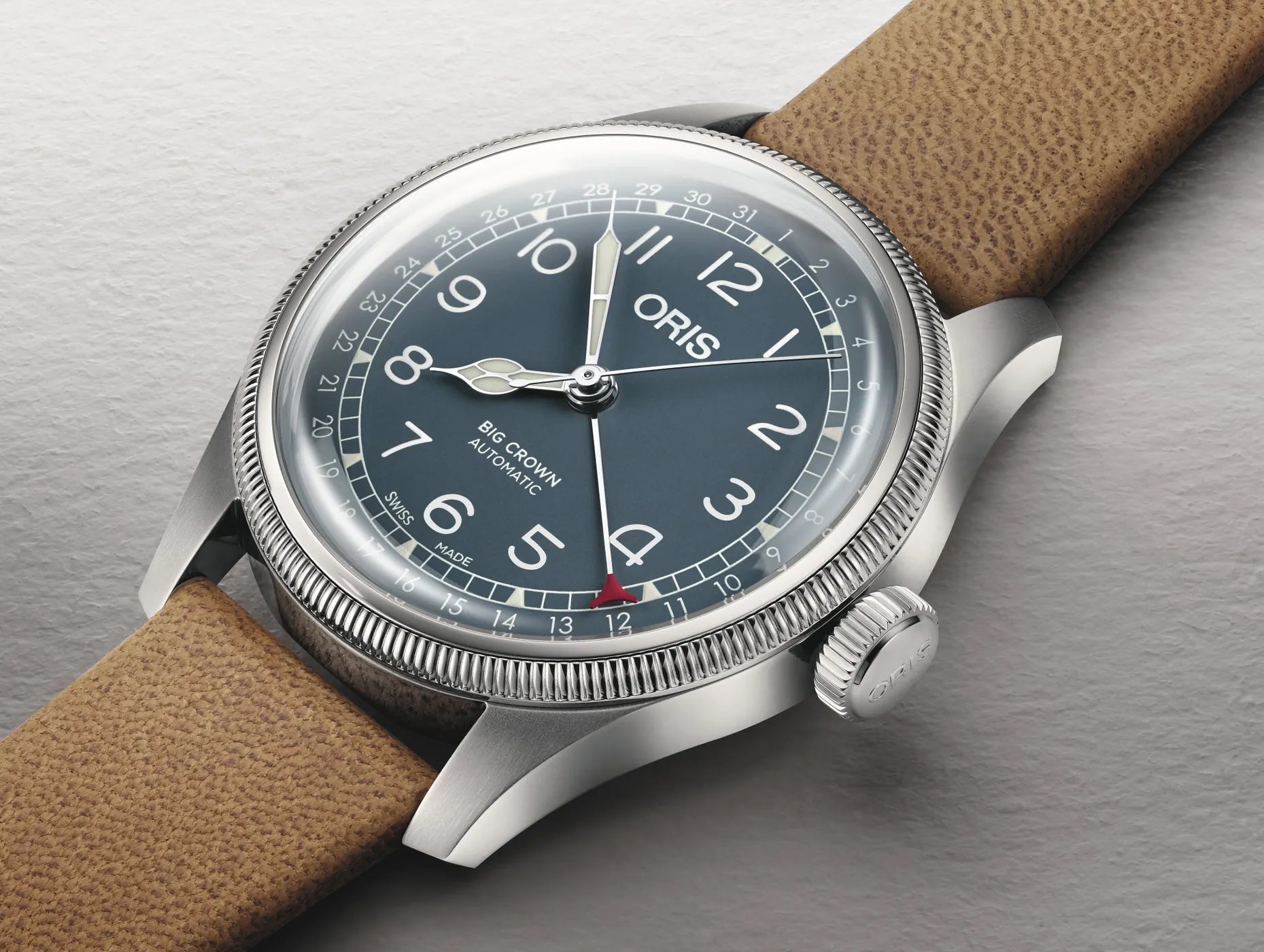 Oris watch with brown leather strap on a gray background