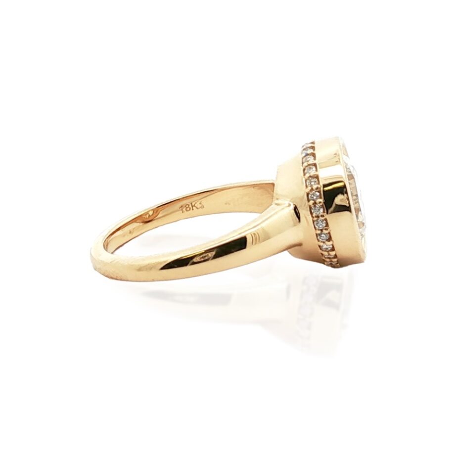 Side view of 4.29ctw diamond engagement ring, 18K yellow gold, round center with halo and pave diamonds on white