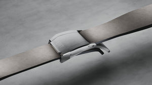 Grey leather strap with silver clasp on a grey background