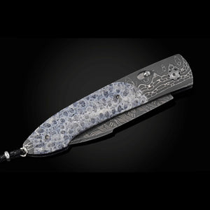 Decorative straight razor with intricate patterns on a black background