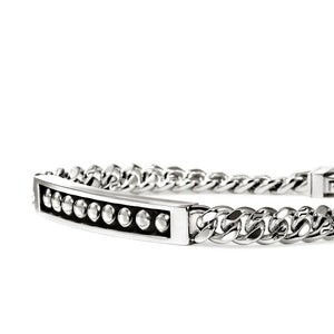 A silver-toned metal chain bracelet with a central bar set with round silver stones, shown on a plain white background.