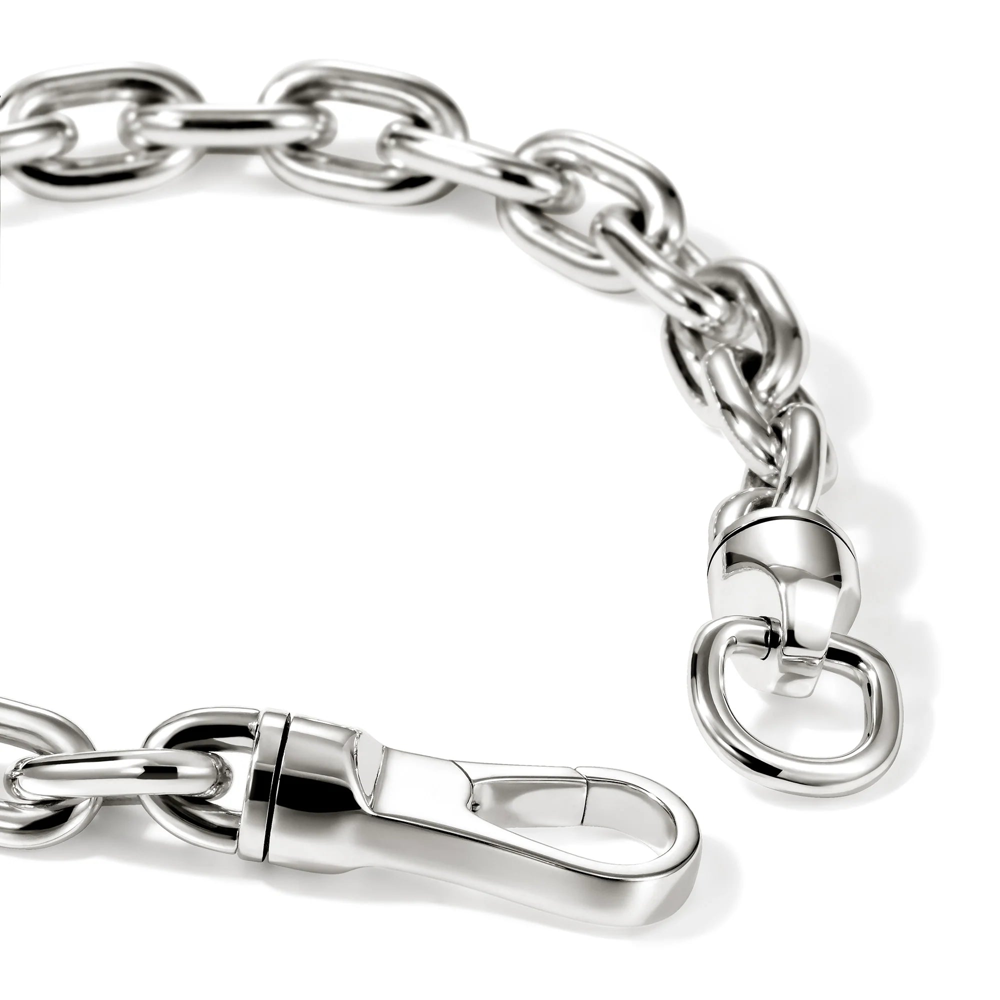 A close-up of a polished silver-tone metal chain with interlocking oval links, a lobster clasp, and a small hanging ring, photographed on a clean white background.