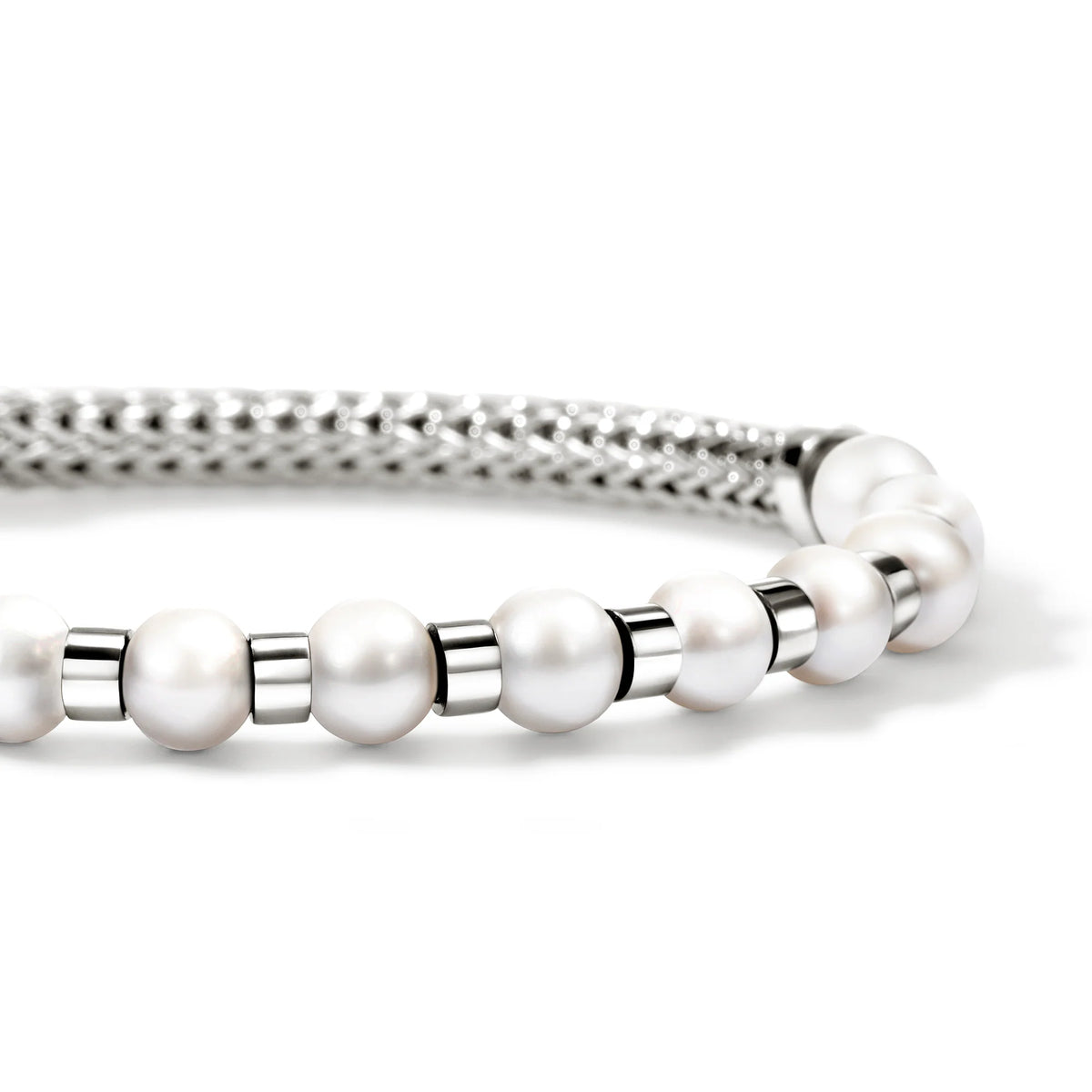 close up of pearls and silver bracelet on a white background