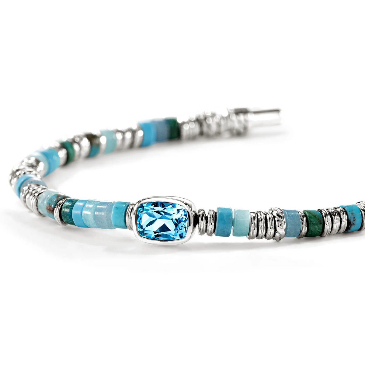 A beaded bracelet featuring light blue and turquoise beads, textured silver spacers, and a central light blue faceted gemstone in a silver bezel setting, shown on a white background.