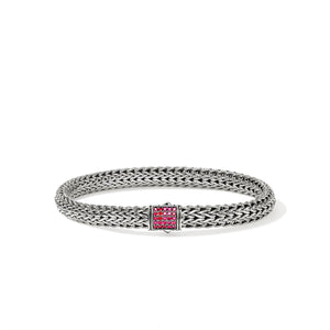 Silver bracelet with a red gemstone on a white background