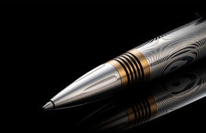 Angled close-up of William Henry Caribe 16 pen showing damascus stainless barrel and brass spacer rings on black background