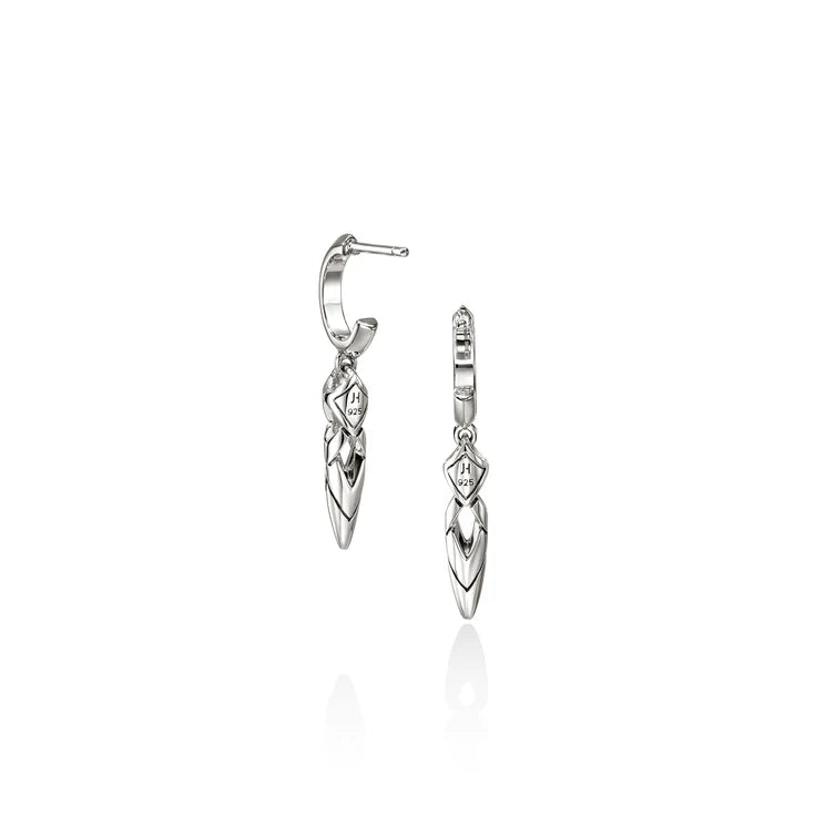 A pair of silver huggie hoop earrings with dangling leaf-shaped charms, shown on a clean white background with a soft reflection below.