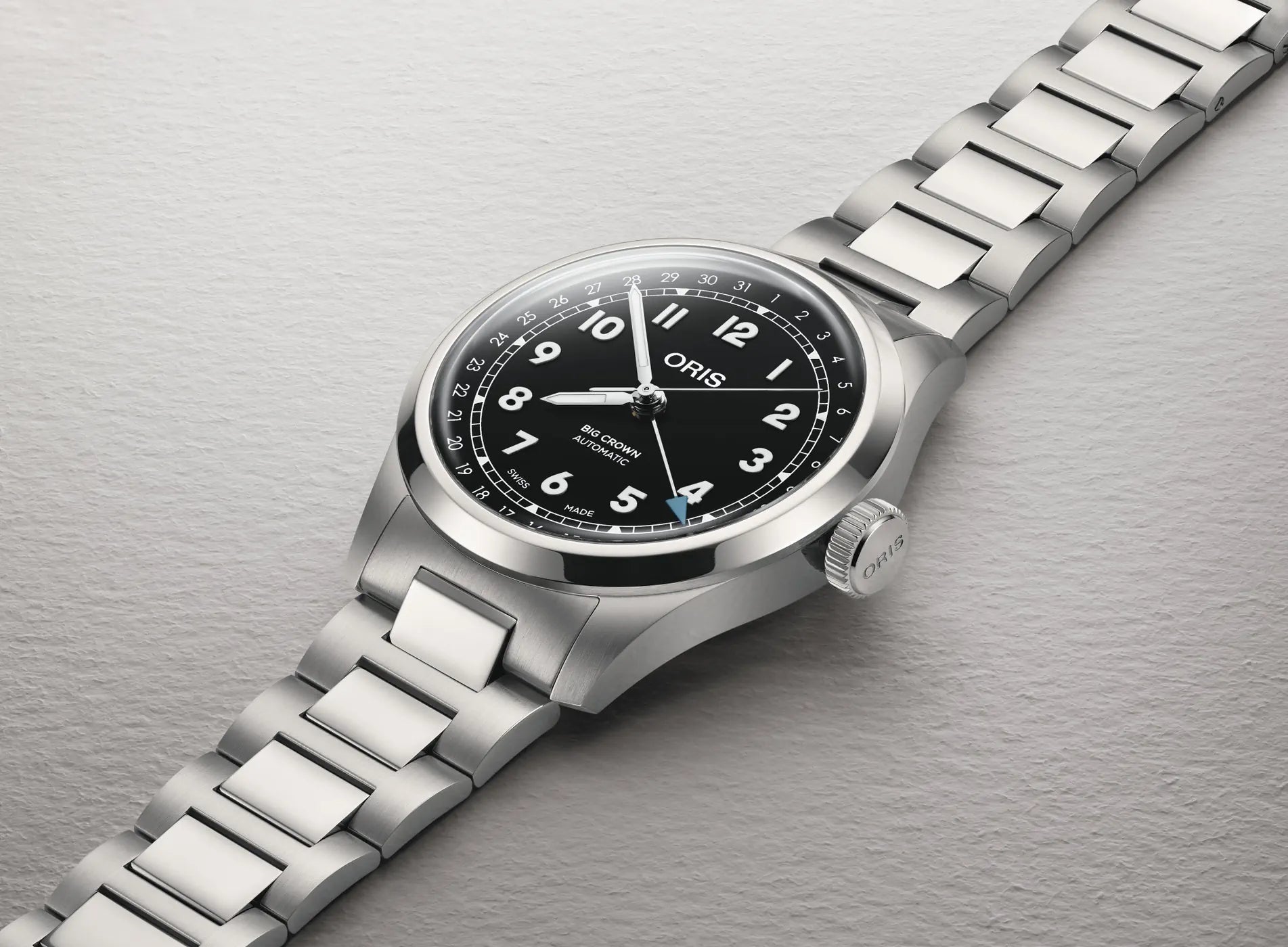 Silver Oris watch with black dial on a gray background