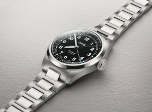Silver Oris watch with black dial on a gray background