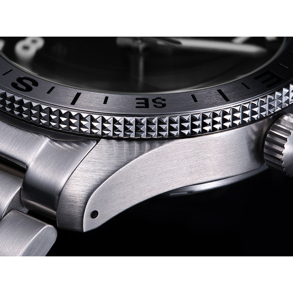 Close-up of a silver watch with detailed bezel and crown.