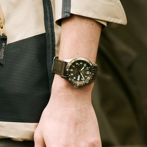 Person wearing a wristwatch with a blurred background