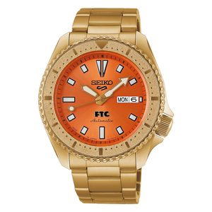 Goldtone Seiko watch with orange dial on a white background