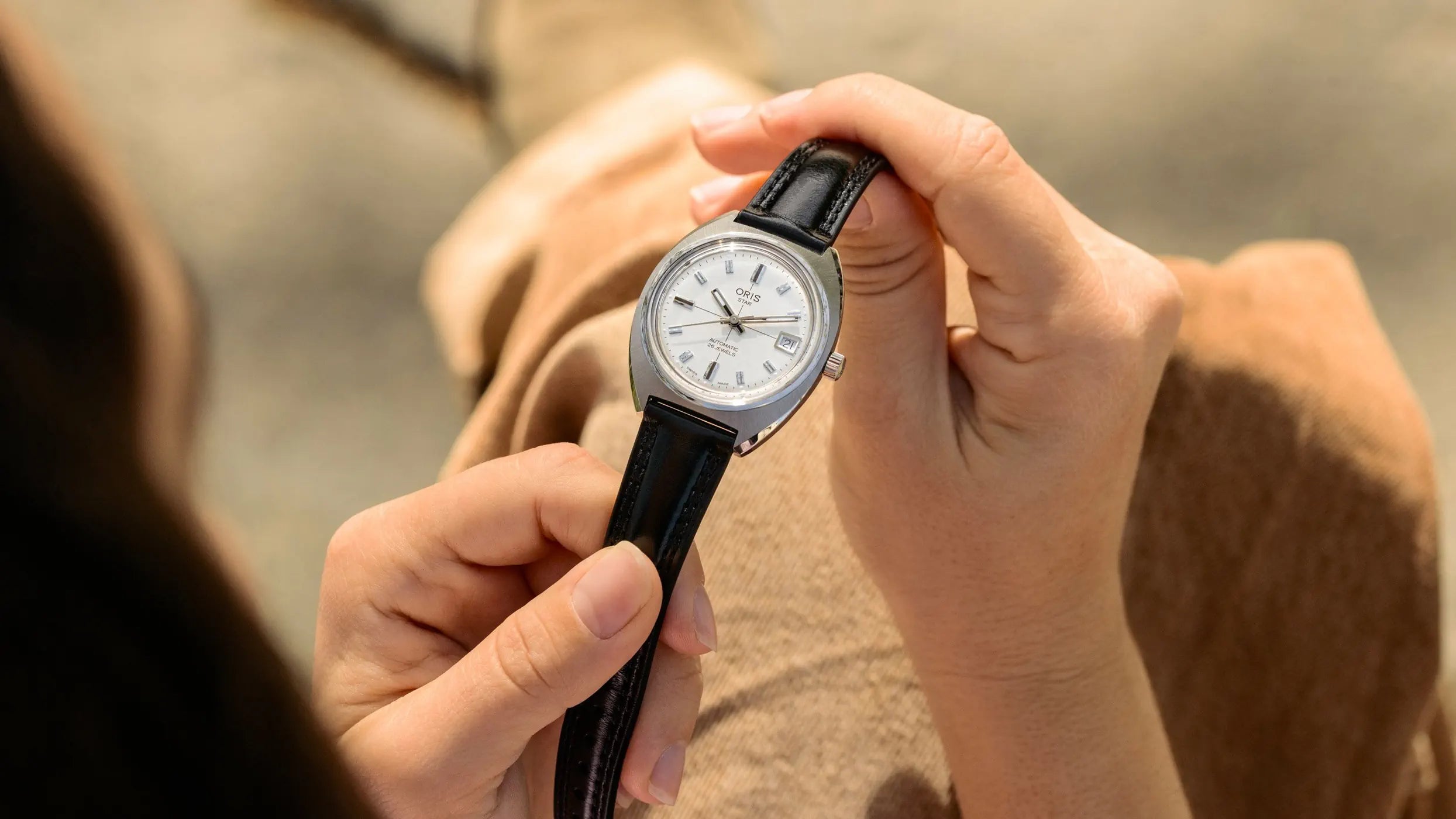 Person holding a watch with a blurred background