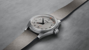 Oris watch with a gray strap on a gray background