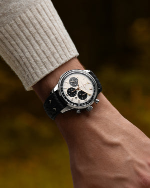 Wrist shot of Freedom 60 Chrono 43mm watch, off-white dial, black perlon strap, stainless steel case, blurred autumn background