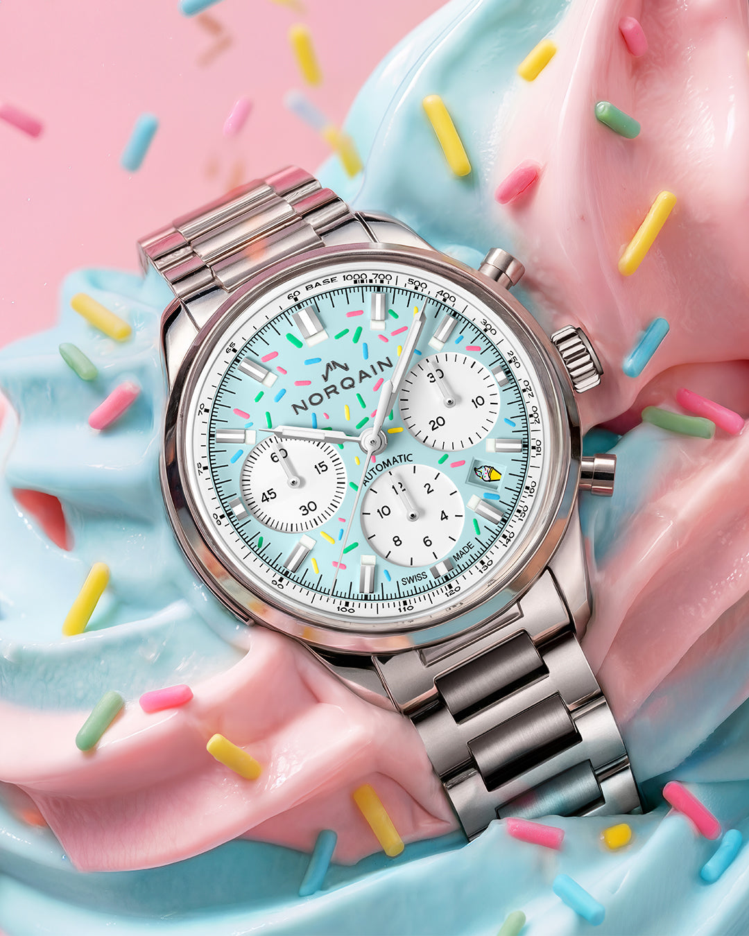 Silver watch with a colorful face on a donut with sprinkles