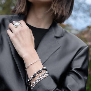 close up of a woman in a black leather jacket wearing multiple silver bracelets