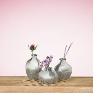 Front view of Posey Vase Large with reflective silver finish and etched leaf pattern on wooden table