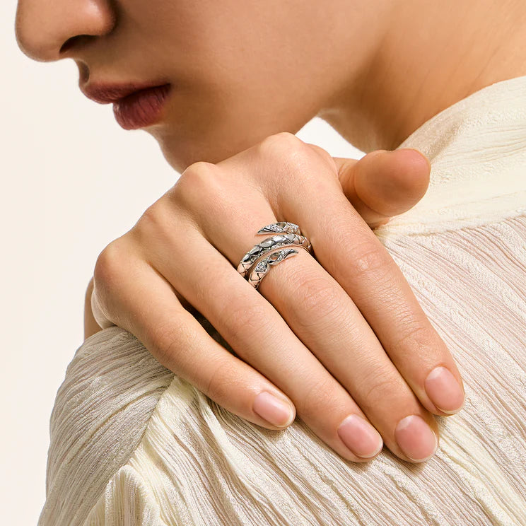 Close-up of a hand wearing two rings with a neutral background