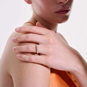 Hand model wearing a slim silver band with three small diamonds (Surf ring) on the ring finger