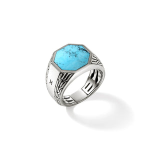 Angled view of Turquoise signet ring showing octagonal turquoise stone and carved sterling silver on white background