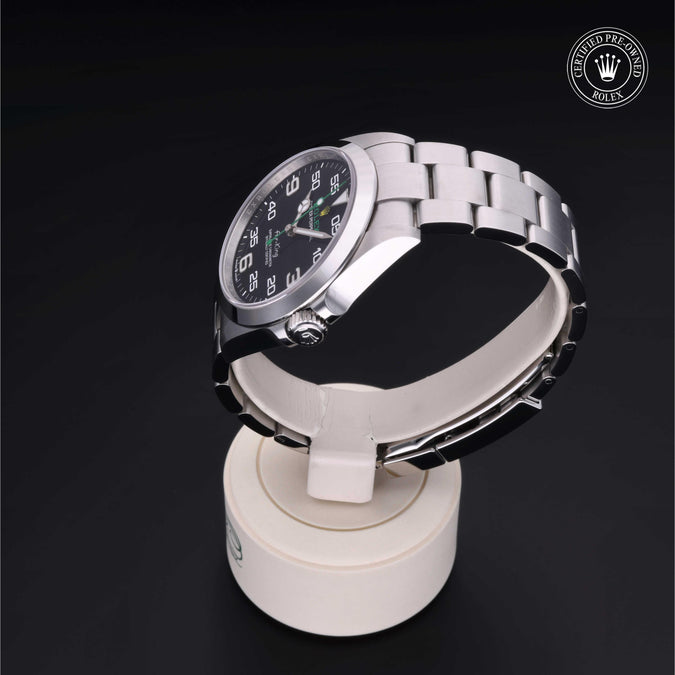 Gold watch on a white stand with a black background