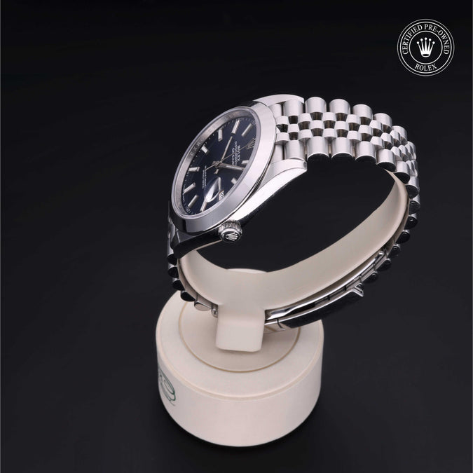Gold watch on a white stand with a black background