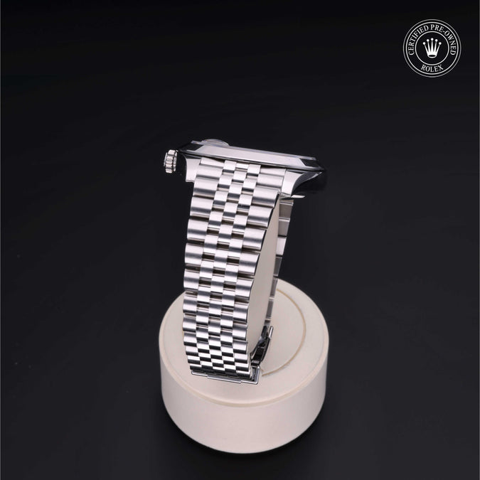 Silver watch strap on a stand with a dark background