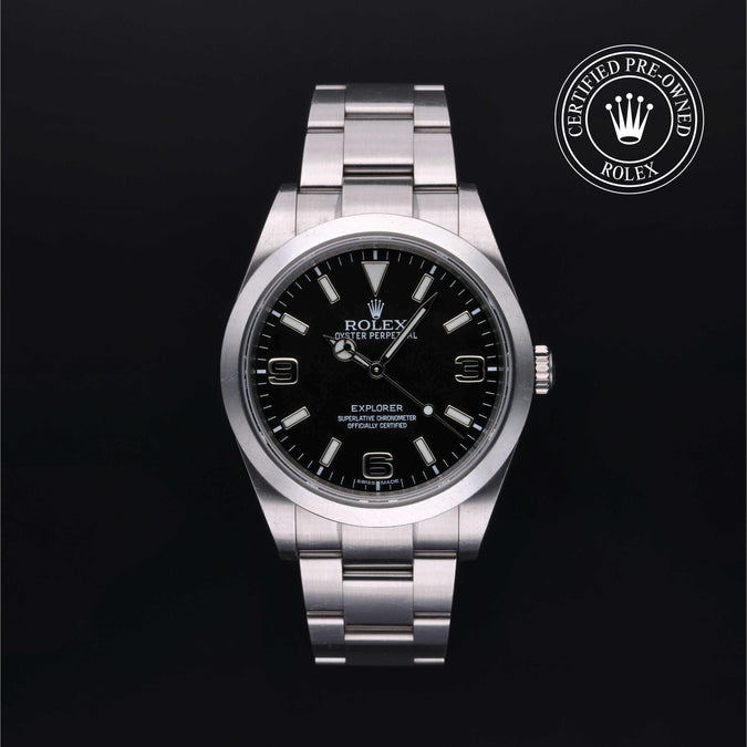 Rolex watch with black dial on a dark background, featuring the Rolex logo.