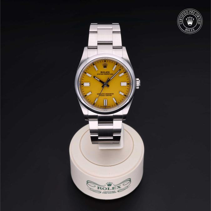 Rolex watch with yellow face on a white stand against a black background